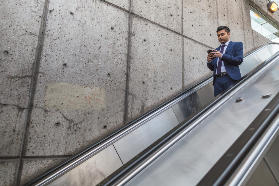 hombre al teléfono en una escalera mecánica