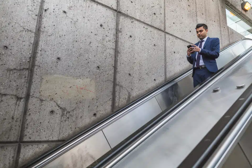 hombre al teléfono en una escalera mecánica