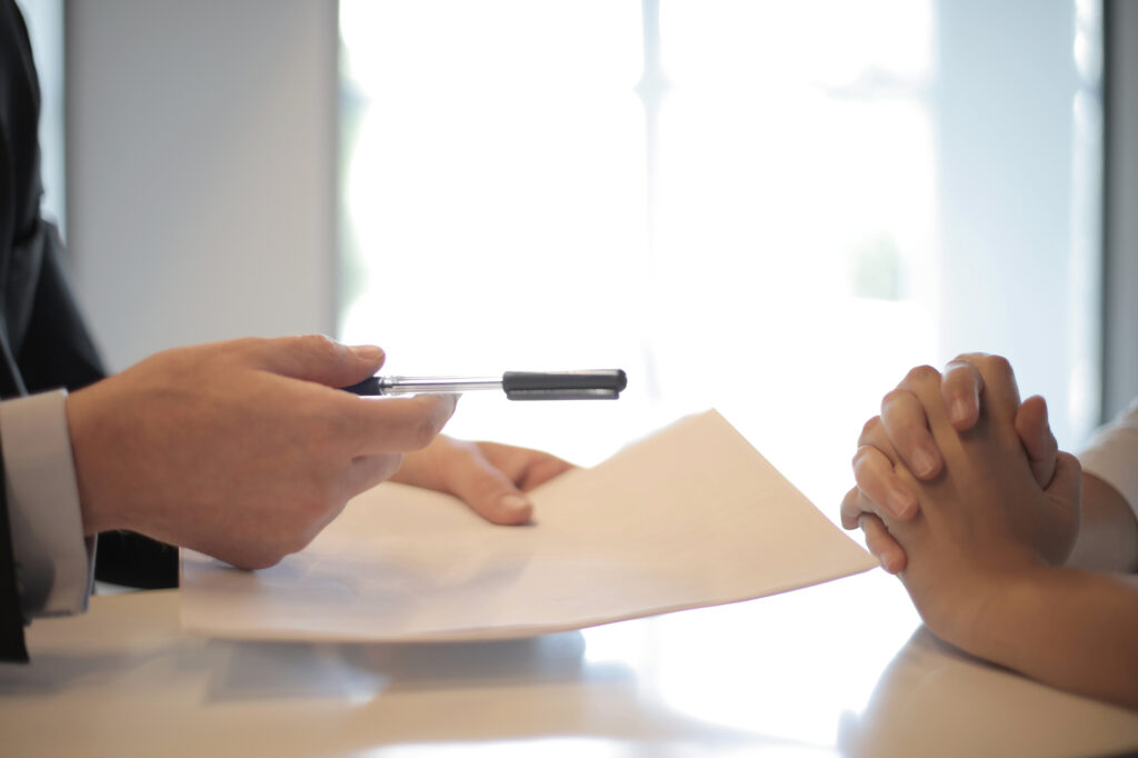 man holding out pen for signature