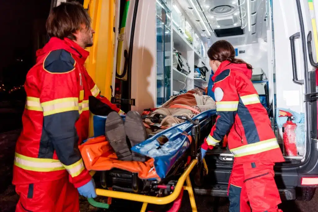 paramédicos colocando a alguien dentro de la ambulancia