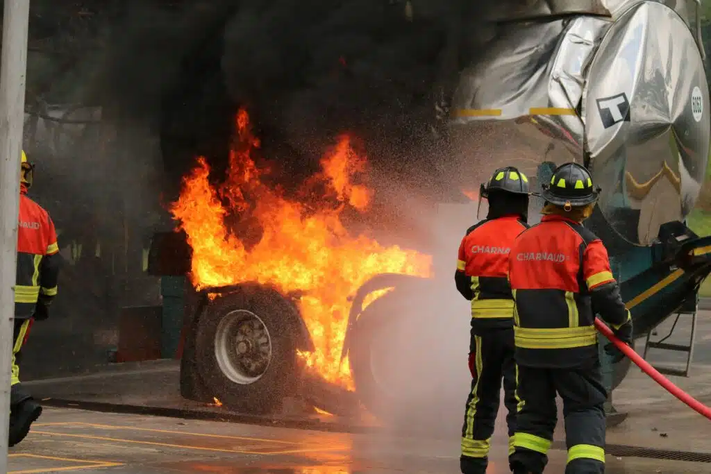 Los bomberos se agrupan alrededor de un camión en llamas y trabajan sin descanso para extinguir el fuego y garantizar la seguridad.